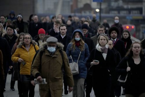 I lavoratori camminano sul London Bridge verso il quartiere finanziario della città di Londra durante l'ora di punta del mattino, a Londra, lunedì 24 gennaio 2022.