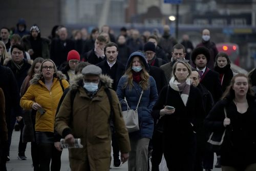 Des travailleurs marchent sur le pont de Londres en direction du quartier financier de la ville de Londres pendant l'heure de pointe du matin, à Londres, le lundi 24 janvier 2022.