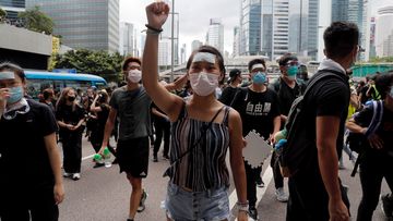 Protesters march to surround the police headquarters in Hong Kong.