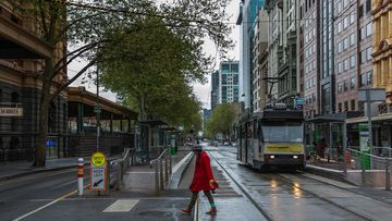 A lone woman is seen crossing the usually busy Flinders Street Elizabeth Street intersection on September 25, 2020 in Melbourne, Australia. 