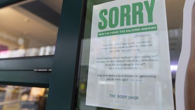 A sign hangs outside a shop apologising for closing its doors as lockdown due to the continuing spread of the coronavirus starts in Melbourne, Wednesday, Aug. 5, 2020. 