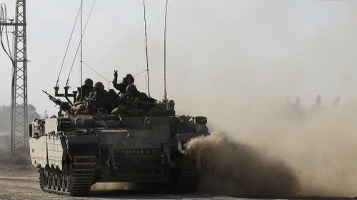 An Israeli tank drives along the border between Israel and Gaza. (AAP)