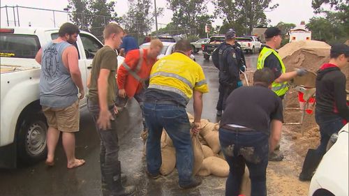 Bénévoles et locaux faisant des sacs de sable à Windsor, sur la rivière Hawkesbury.