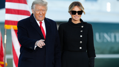 President Donald Trump gestures as first lady Melania Trump looks on before giving a speech to supporters at Andrews Air Force Base, Md., Wednesday, Jan. 20, 2021. (AP Photo/Luis M. Alvarez)