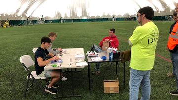 The world record for the farthest flight by paper airplane has been broken by three aerospace engineers with a paper aircraft that flew the length of an American football field. Ruble (from left) and Erickson fold their paper airplanes with witnesses overseeing.