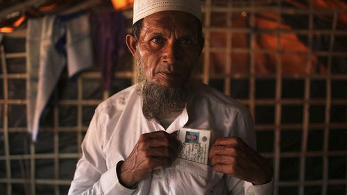 Abdul Jabar, 61, holds on to one thing he carries around with him constantly, by his heart in the pocket of his shirt, an identification card belonging to his late son whom he said was slain by members of Myanmar's armed forces. (AAP)
