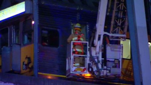 Rescue crews used a cherry picker to reach the trapped driver. (9NEWS)