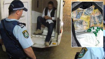 NSW Police escort an arrested suspect out of a police vehicle, following a raid on a Sydney storage locker where $1.3 million was found.