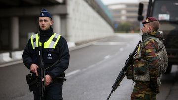 A Belgian police officer and a soldier stand guard at Brussels airport.