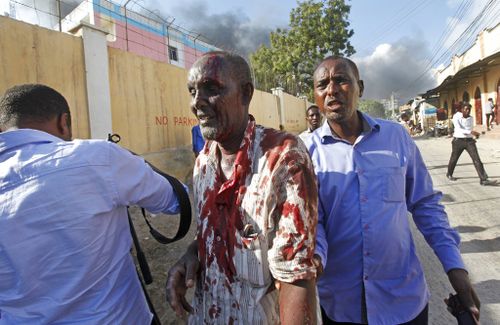 Somalis help a man wounded after a blast in the capital Mogadishu. (AP)