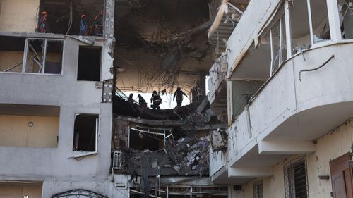 Rescue workers remove rubble from a residential building which was hit by a rocket the previous day on in Odessa, Ukraine.