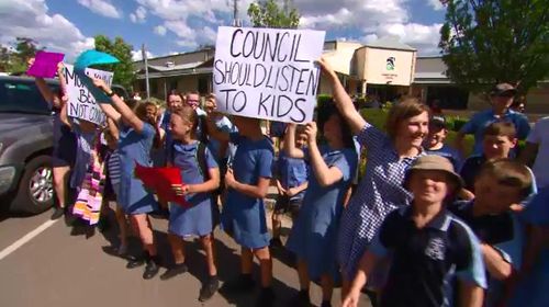 The kids made a noise outside the council building.