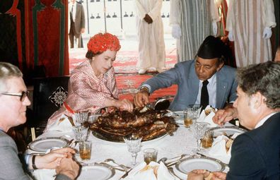 Queen Elizabeth II eats with her hands in the desert with King Hassan during her visit to Morocco on October 27, 1980.