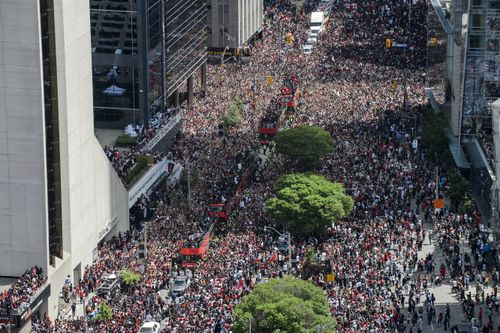 Fans cheer during the Toronto Raptors NBA basketball championship victory parade in Toronto. (Andrew Lahodynskyj/The Canadian Press via AP)