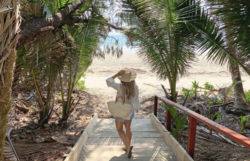 Marriott hotels | Woman walking down towards a beach