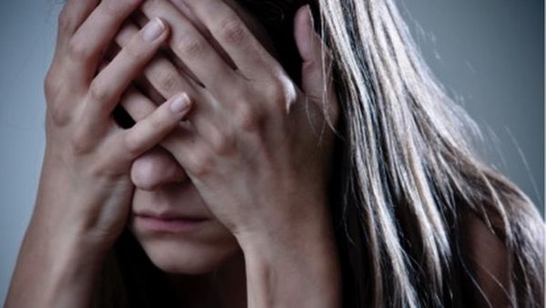 Woman with hands over her face.