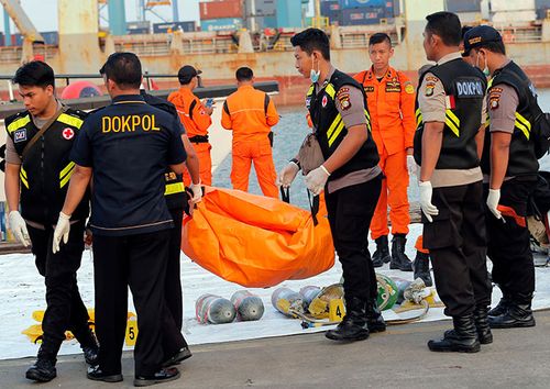 Police officers carry a body bag containing the remains recovered from the area where a Lion Air passenger jet crashed, at Tanjung Priok Port in Jakarta, Indonesia.