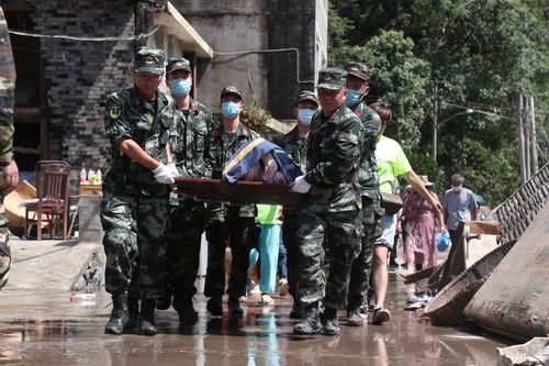 Chinese rescuers carry a victim after a landslide caused by the Typhoon Lekima.