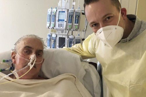 เดวิด เบนเน็ตต์ จูเนียร์ (ขวา) ยืนอยู่ข้างเตียงในโรงพยาบาลของพ่อในบัลติมอร์