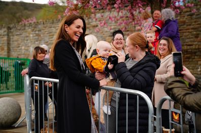 MERTHYR TYDFIL, WALES - APRIL 28: Lucy Williams, from Aberfan, holds her son Daniel Williams, one, as he takes the handbag of the Princess of Wales, during her visit with her husband the Prince of Wales, to the Aberfan memorial garden, to pay their respects to those who lost their lives during the Aberfan disaster on October 21st 1996, on their 2 day visit to Wales on April 28, 2023 in Merthyr Tydfil, United Kingdom. The garden sits on the site of the Pantglas school which was tragically destroy