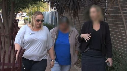 A government worker (left) escorts a woman facing court for the child abuse (middle) and her legal representative.