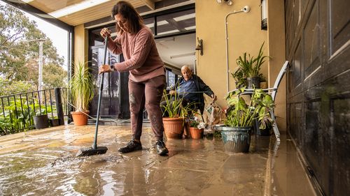 Photo shows Solly and his daughter Serine cleaning up after the flooding of the Maribyrnong River. Solly has lived on Chifley Drive for 15 years and says this is by far the worst flood he has seen here. 