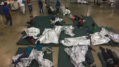 Children taken into custody related to cases of illegal entry into the United States, rest in one of the cages at a facility in McAllen, Texas. (AAP)