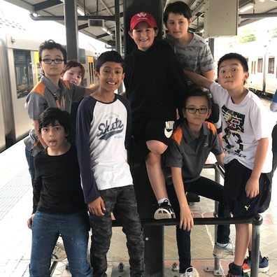 Alec alongside his friends about to board their private train. 