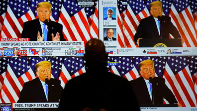 A live broadcast of President Donald Trump speaking from the White House is shown on screens at an election-night party, Tuesday, Nov. 3, 2020, in Las Vegas. (AP Photo/John Locher)
