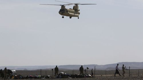 An Egyptian military helicopter lands near the wreckage of a passenger jet. (AAP)