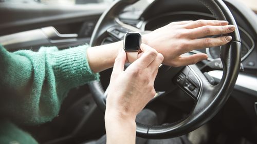 Woman using a smart watch in car. close up