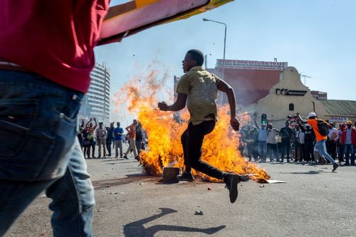 People gather around a fire on the street during a protest against polling results in Harare, Zimbabwe, 01 August 2018 (issued 02 August 2018). The day saw protests turn violent when police fired rubber bullets and teargas, before the army was called in and began firing live rounds. EPA/YESHIEL PANCHIA