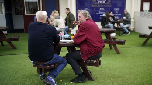 People enjoy a drink on the promenade on October 16, 2020 in Blackpool, England. The Lancashire region will go into Tier 3 of Covid-19 lockdown restrictions from 00.01 Saturday 17th October.