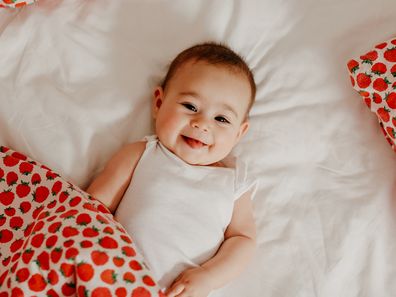 A baby girl laying on a bed 