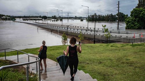 Locals watch as the Windsor Bridge is swallowed by floodwater from the Hawkesbury River, north of Sydney.
