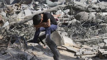 A Palestinian boy sits on the rubble of the building destroyed in an Israeli airstrike in Bureij refugee camp Gaza Strip, Wednesday, Oct. 18, 2023 