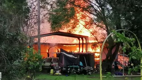 A Queensland family of eight has escaped a burning house after receiving the help of a complete stranger.