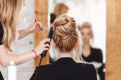 A woman having her hair cut by a hairdresser