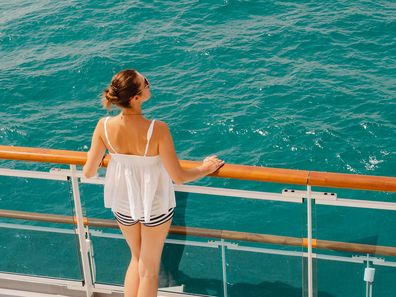 Woman standing on a cruise ship.