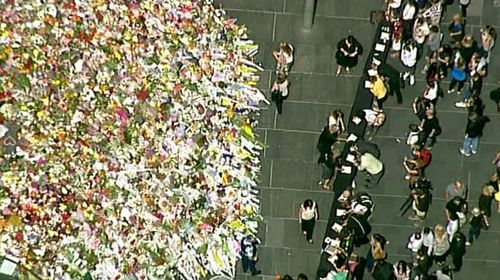 Martin Place has been flooded in a sea of colour as people share in their grief for the victims and hostages of the Lindt cafe siege. (9News)