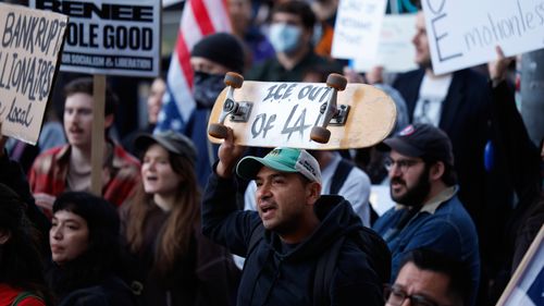 Demonstrators hold signs during a protest in response to the fatal shooting of 37-year-old Alex Pretti in Minneapolis earlier in the day Saturday, Jan. 24, 2026, in Los Angeles. (AP Photo/Caroline Brehman)