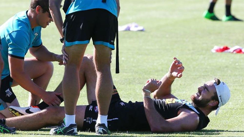 Charlie Dixon winces after injuring his knee at training.