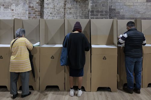 People cast their ballots during early voting for the seat of Wentworth at Oxford Street Mall on May 20, 2022 in Sydney, Australia. Independent Allegra Spender is standing for the seat of Wentworth against Liberal incumbent Dave Sharma. The Australian federal election will be held on Saturday 21 May 2022. (Photo by Brook Mitchell/Getty Images)