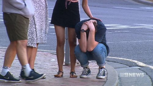 Mr Hanley's distraught friends at the scene. (9NEWS)