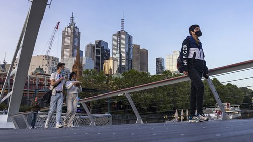 People walk across a footbridge in Southbank in Melbourne.