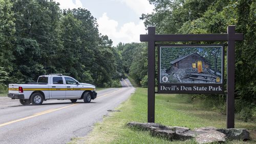 An Arkansas Park Ranger patrols the South Entrance of Devils Den State Park Monday, July 28, 2025, in West Fork, Ark. Police in Arkansas are searching for a suspect in the deaths of a couple who investigators said were attacked while on a wooded walking trail with their two young daughters.  (AP Photo/Michael Woods)