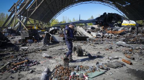 A Ukrainian sapper searches for unexploded explosives at the remains of the Antonov An-225, the world's biggest cargo aircraft destroyed during recent fighting between Russian and Ukrainian forces, at the Antonov airport in Hostomel.