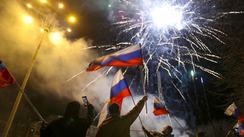 People wave Russian national flags celebrating the recognizing the independence in the centre of Donetsk, the territory controlled by pro-Russian militants, eastern Ukraine.