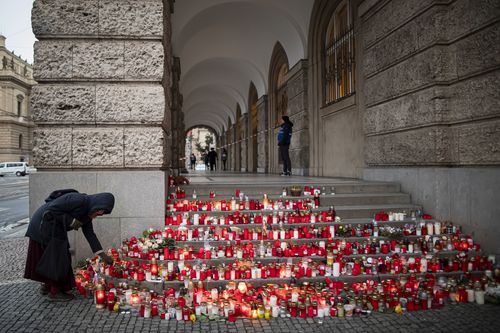 A woman lays a flower outside the building of Philosophical Faculty of Charles University following a mass shooting earlier this week, on December 23, 2023 in Prague, Czech Republic.  