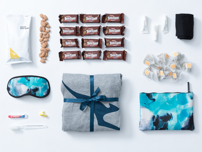 Qantas care package featuring pjamas, amenities and inflight snacks